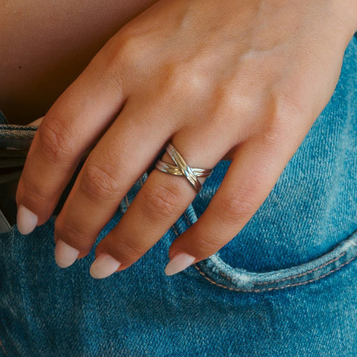 Anel Lifeaskika Cross Ring prateado em aço inoxidável com design cruzado elegante no dedo de uma mulher
