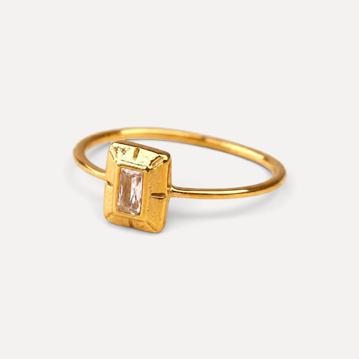 Anel minimalista Lifeaskika dourado com aro fino e detalhe retangular central com pedra clara lapidada